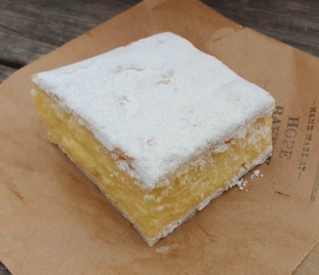 Flaky puff pastry top and bottom, a thick and creamy custard filling packed between the sheets of pasty. The thin pastry less than 25% of the total volume, it's about the custard, not the pastry here. The top coated in either powdered icing sugar, or in vanilla icing.