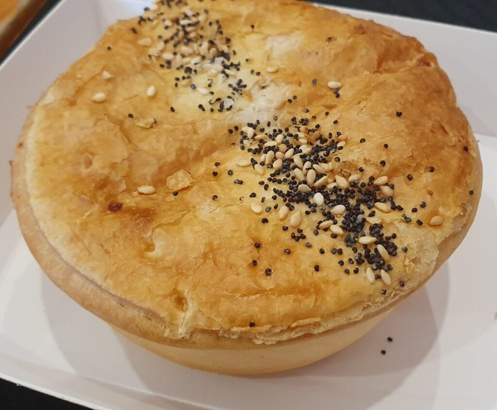 Beechworth Bakery's Caulioccoli pie, a vegetarian icon in Aussie takeaway baked goodness. Using standard pie pastry, the filling is made with cauliflower, broccoli, and a thick cheesy sauce.