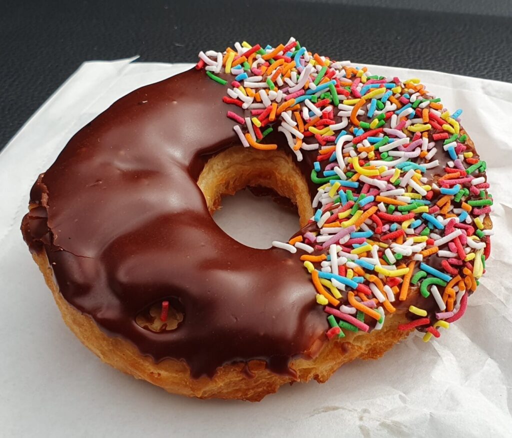 Doughnut - not a donut, we can spell. This golden and fluffy ring of sweetened dough is usually coated liberally in icing (chocolate for the classic, but also strawberry, vanilla, or caramel), or as a solid ball with a hot raspberry jam filling.