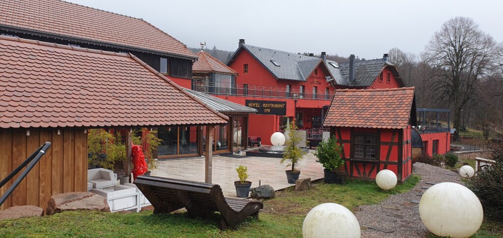 View of Hôtel le Velleda du Donon, on the edge of Mont Donon, in the Bas-Rhin of France. Picture shows the hotel from the side, looking over the entrance, showing the hot tub and sauna.